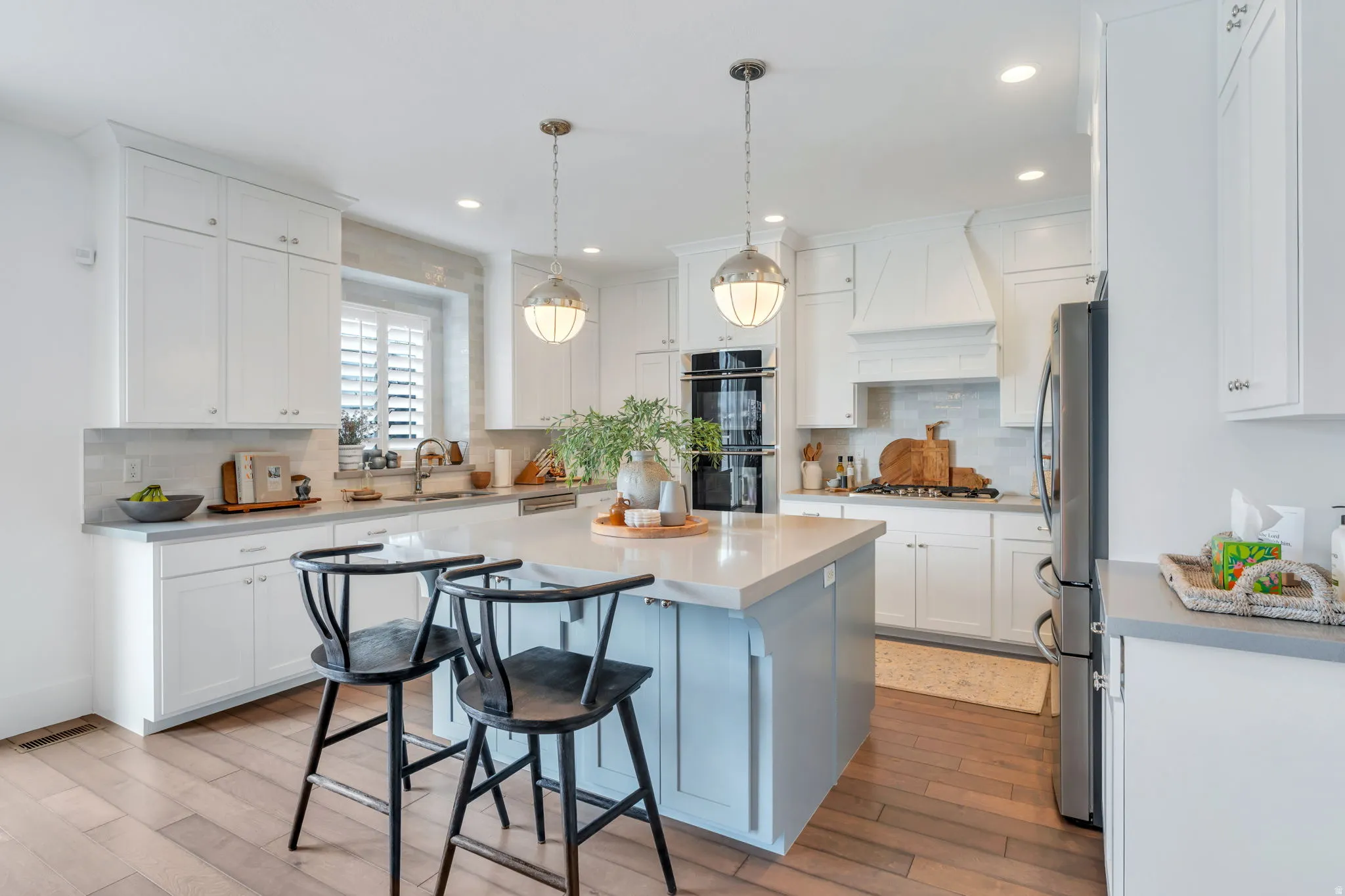 Kitchen featuring a breakfast bar area, a kitchen island, backsplash, stainless steel appliances, and light wood finished floors