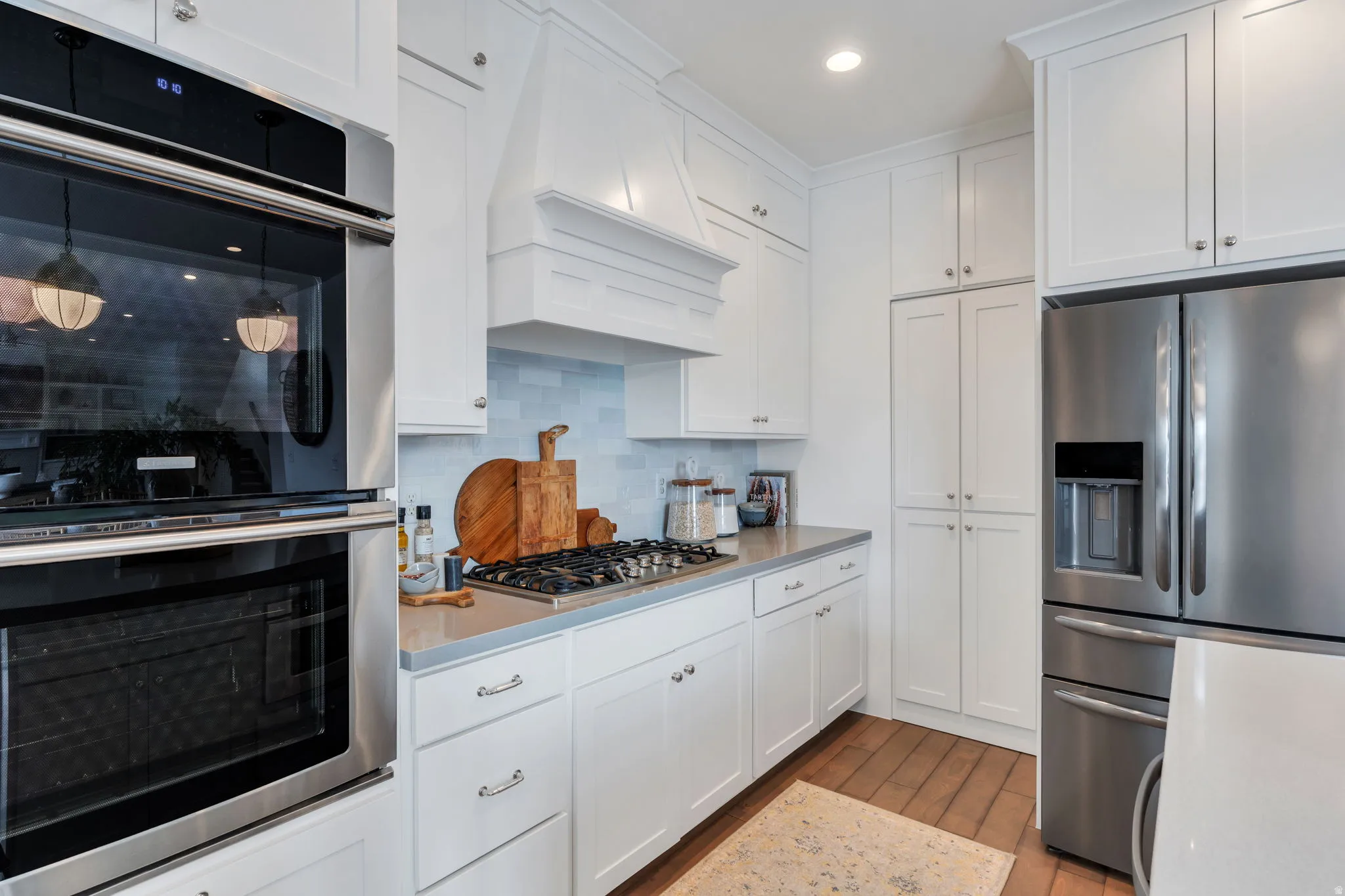 Kitchen featuring stainless steel appliances, white cabinets, dark wood finished floors, tasteful backsplash, and recessed lighting