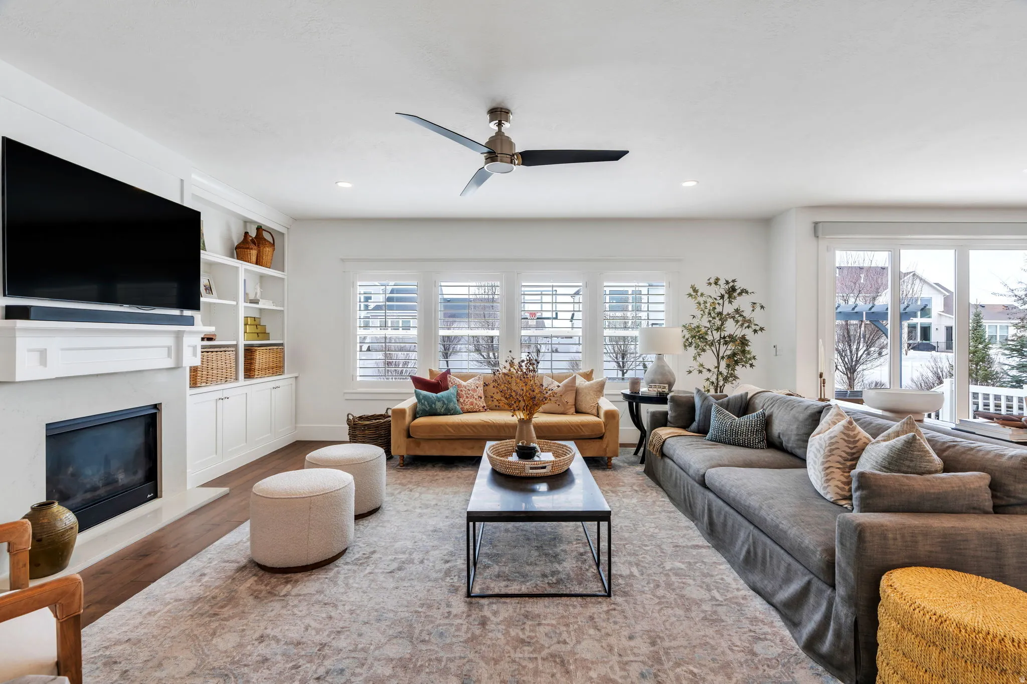 Living area with built in features, healthy amount of natural light, a fireplace, wood finished floors, and recessed lighting