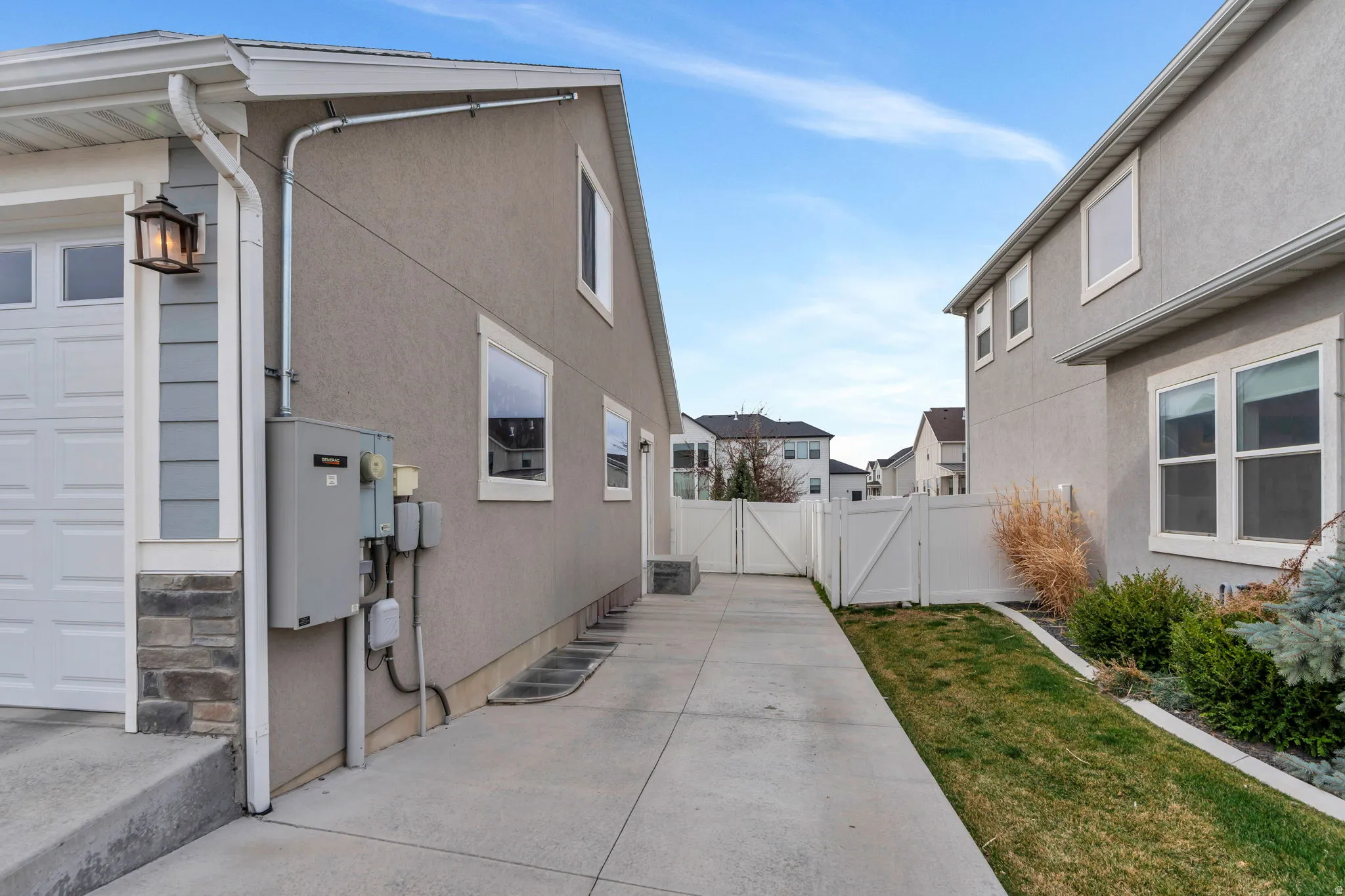View of property exterior featuring a gate, stucco siding, and a residential view