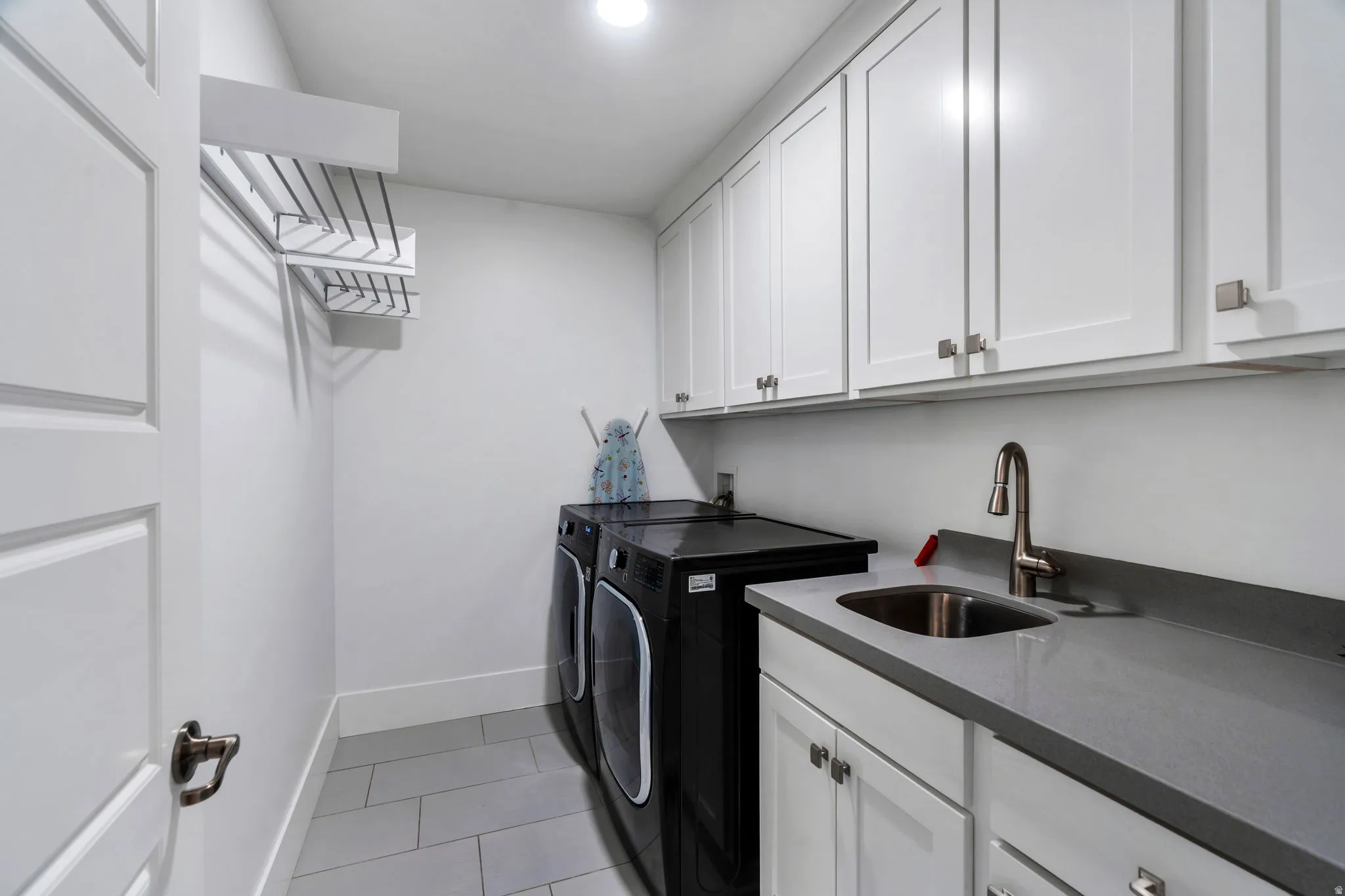 Laundry area featuring cabinet space, washing machine and dryer, and light tile patterned floors