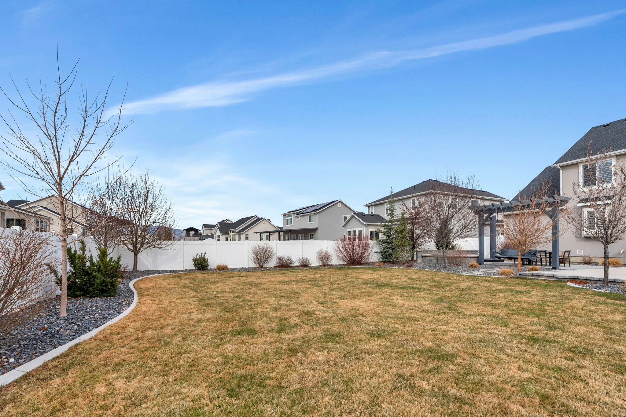 Fenced backyard featuring a residential view, a pergola, and a patio area