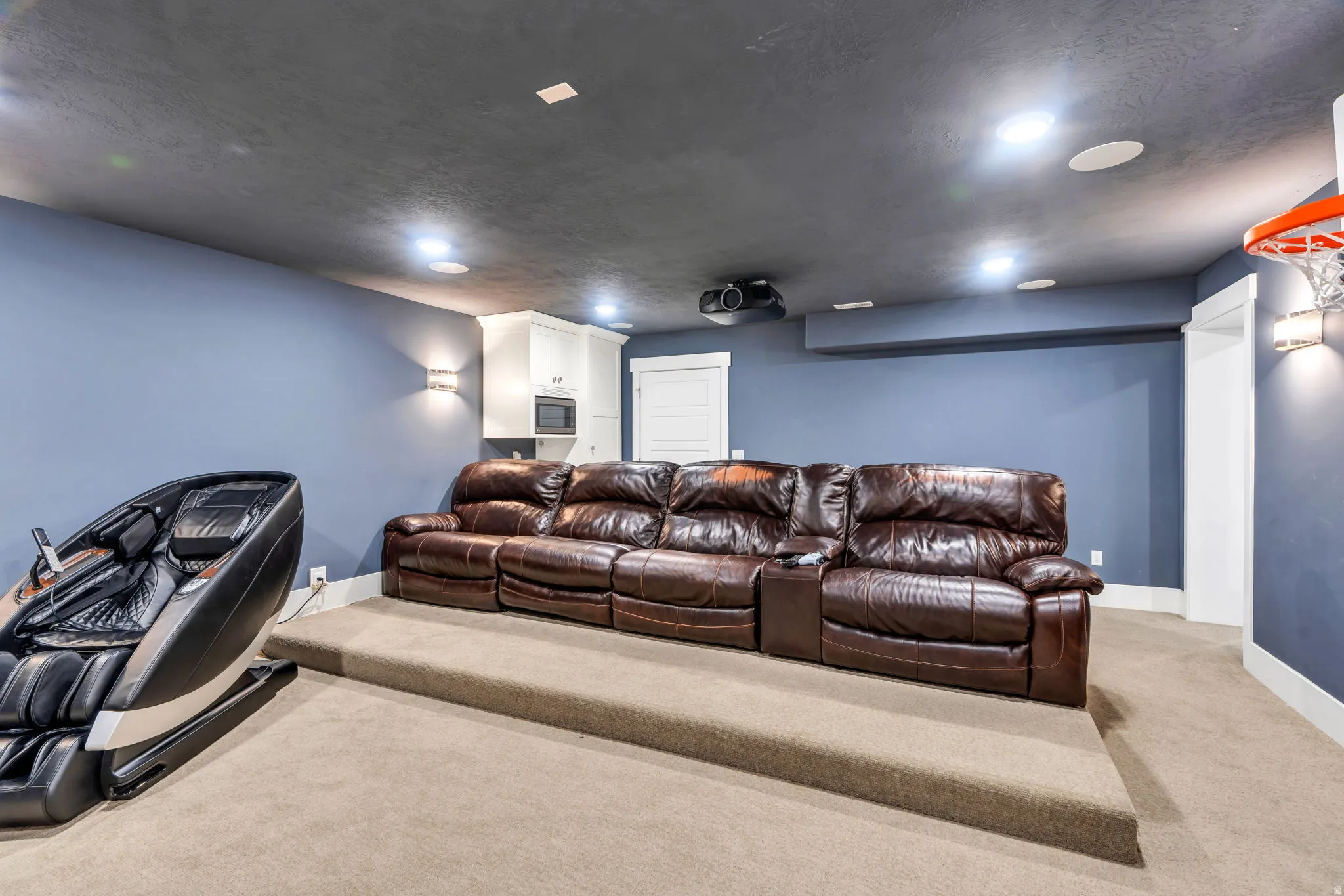 Home theater room with light carpet and recessed lighting