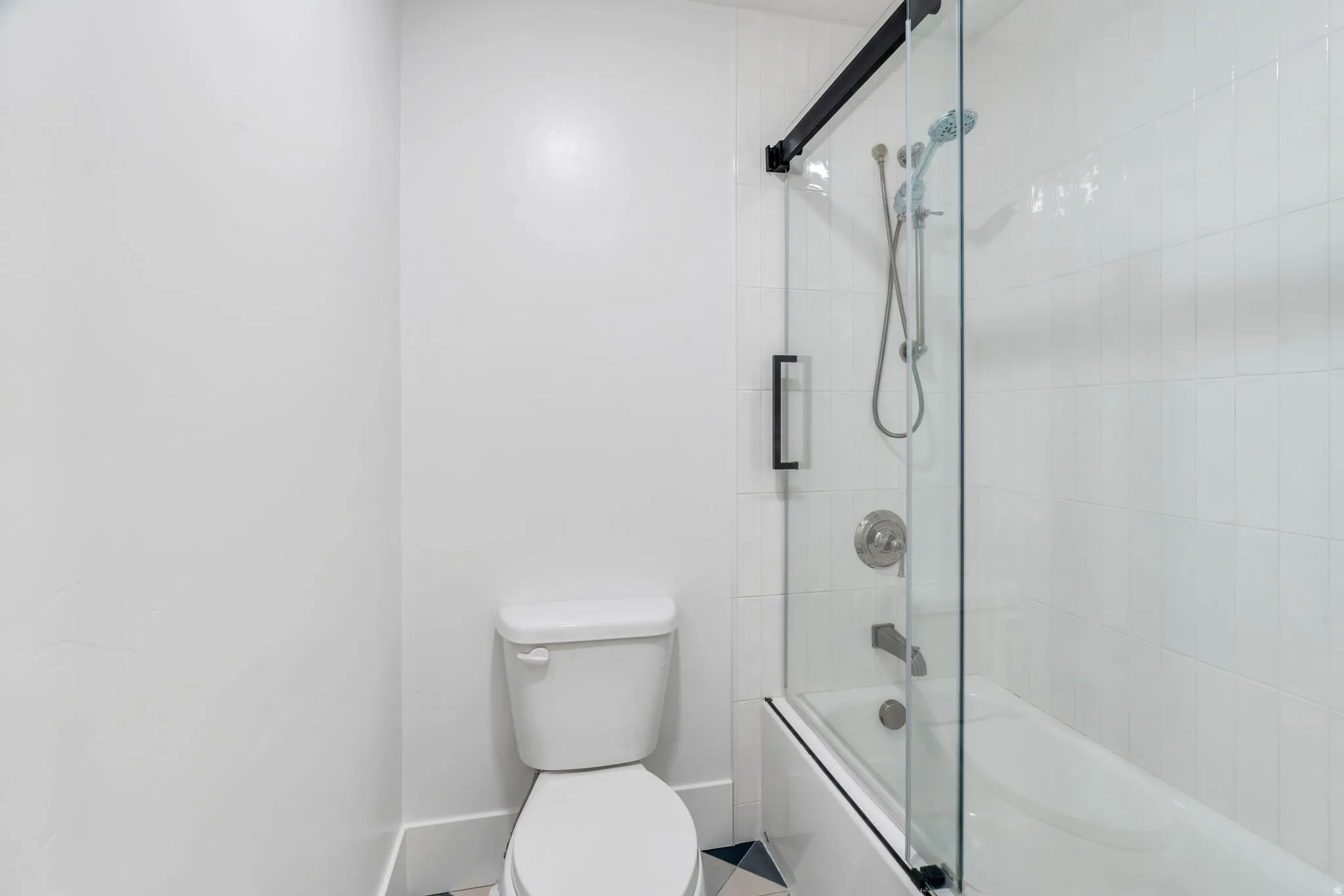 Bathroom featuring toilet and enclosed tub / shower combo