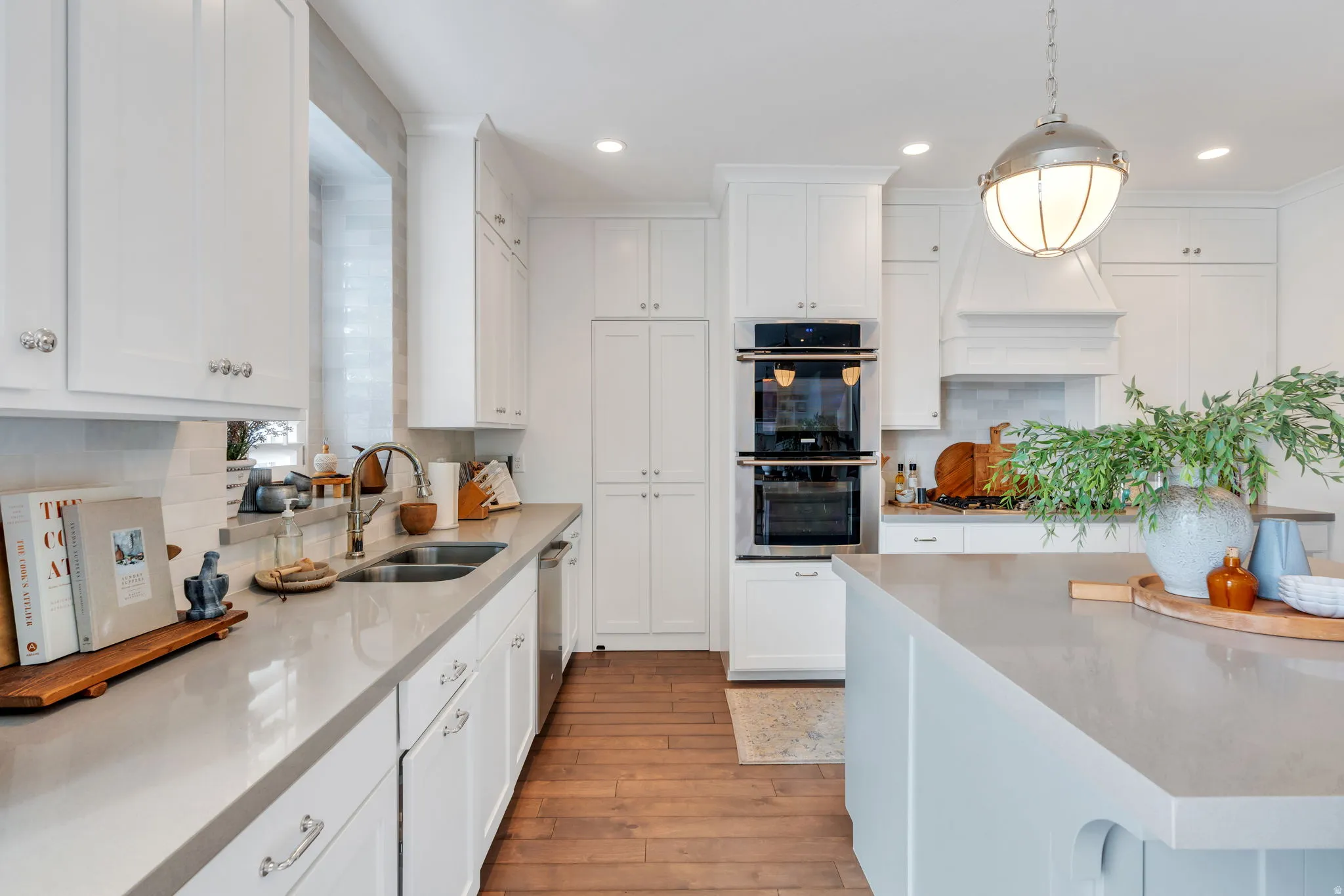 Kitchen featuring stainless steel appliances, white cabinetry, light stone counters, and decorative backsplash