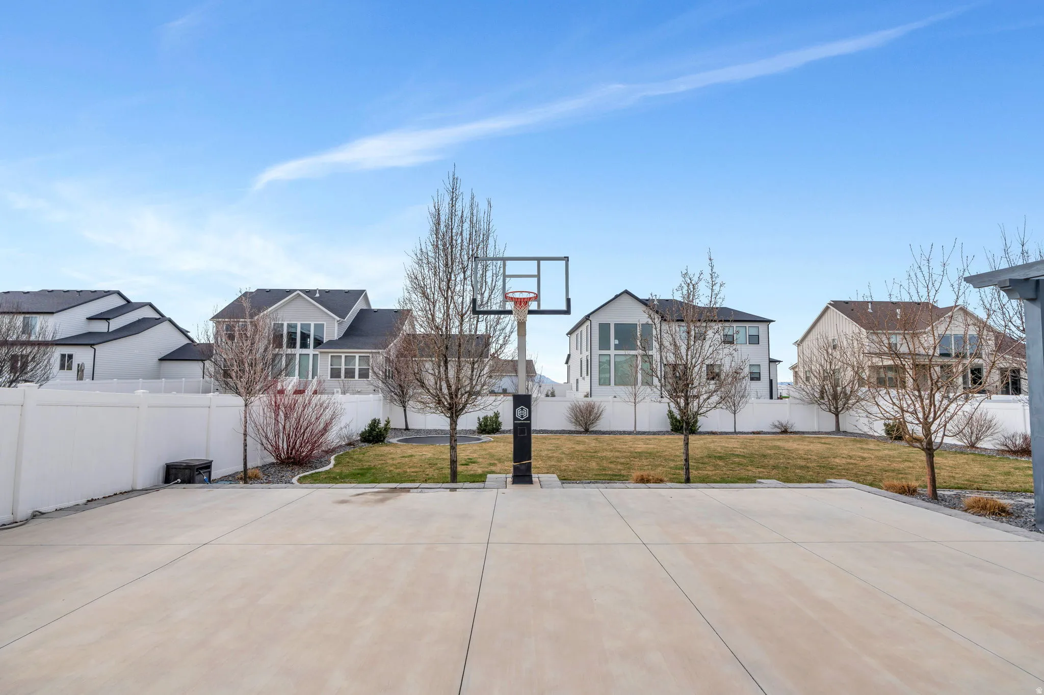 View of sport court with a residential view, a fenced backyard, and basketball hoop
