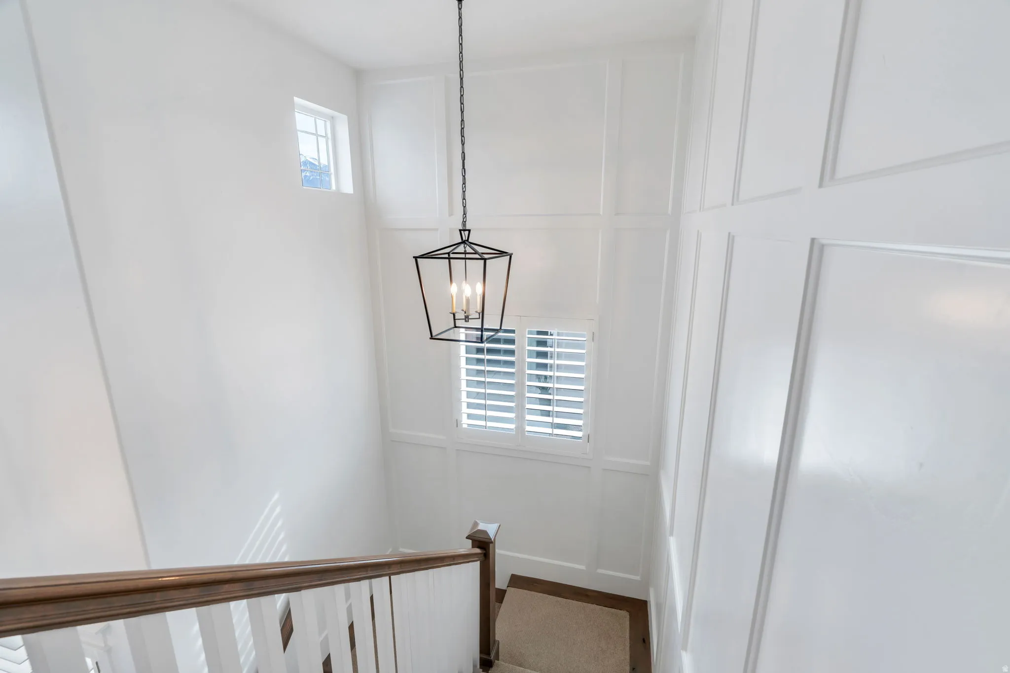 Stairs with a decorative wall and suspended lighting