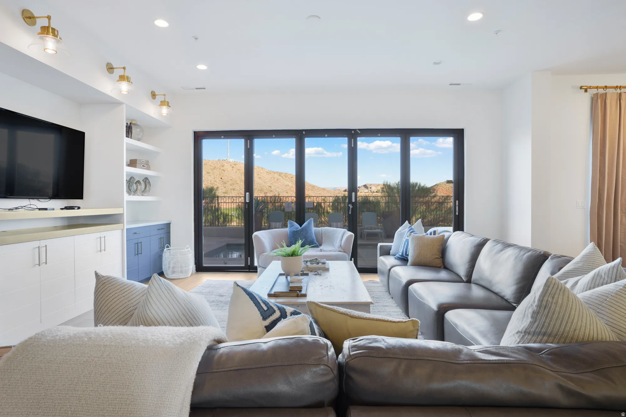 Living room with a mountain view, healthy amount of natural light, wood finished floors, built in features, and recessed lighting