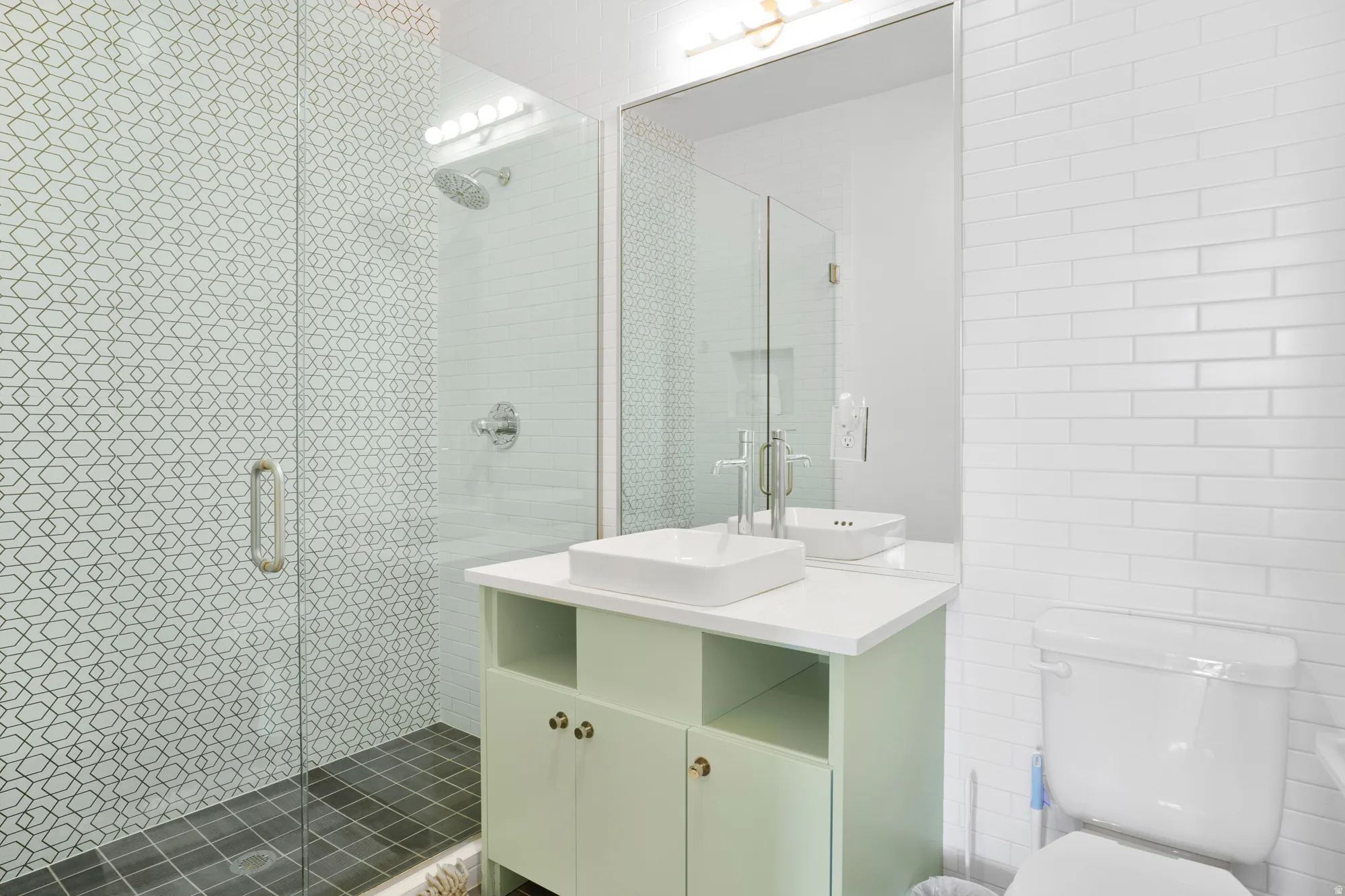 Bathroom featuring vanity, tile walls, and a stall shower