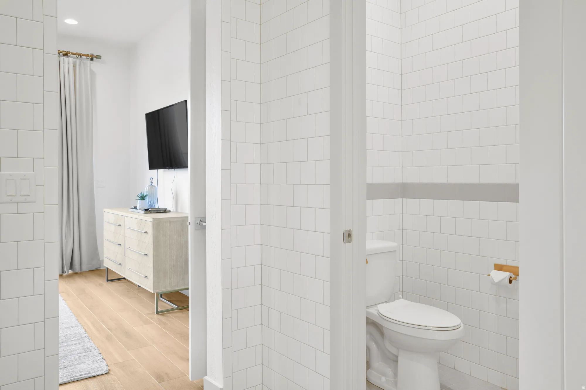 Bathroom with tile walls, light wood-style floors, and vanity
