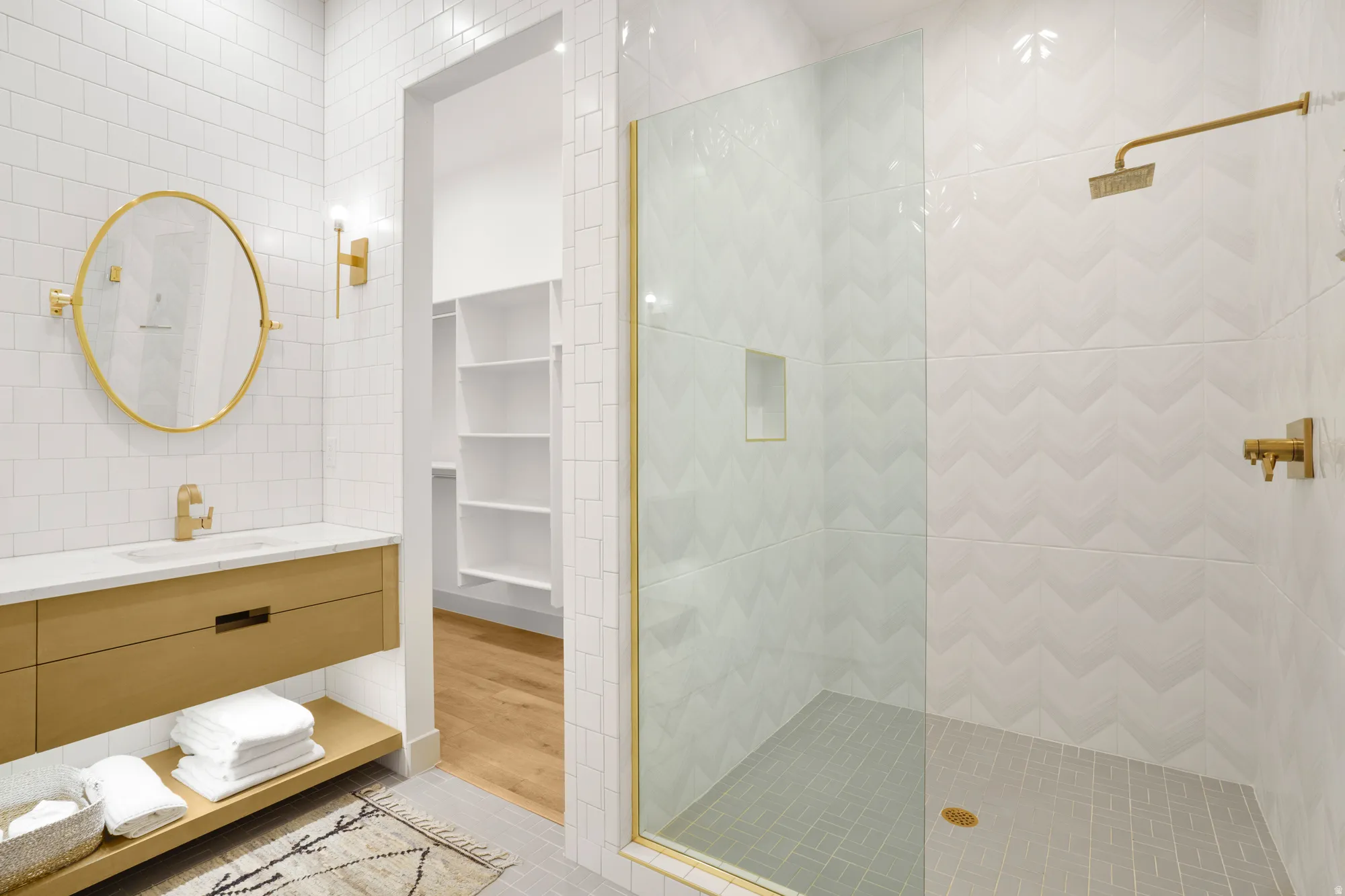 Full bathroom featuring tile walls, vanity, walk in shower, a spacious closet, and built in shelves