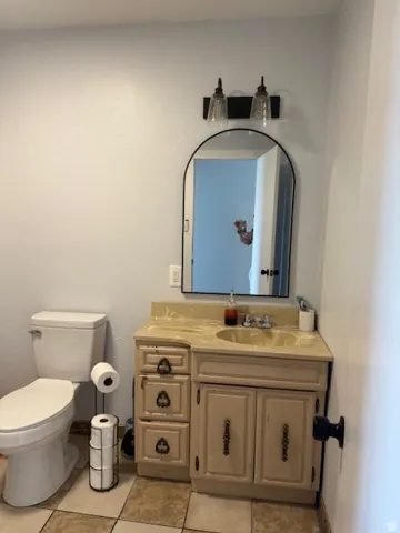 Half bathroom with vanity and light tile patterned flooring