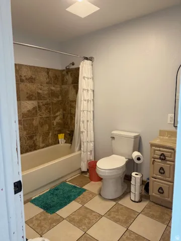 Bathroom featuring vanity and shower / bath combination with curtain