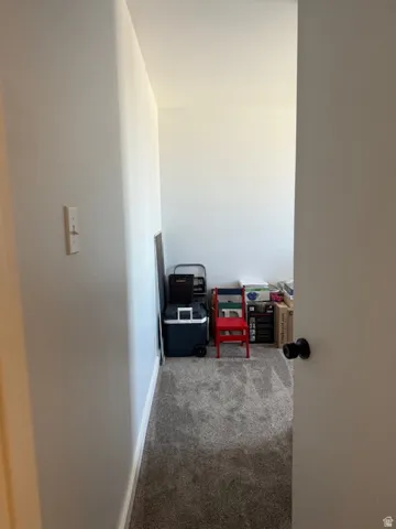 Hallway featuring dark colored carpet