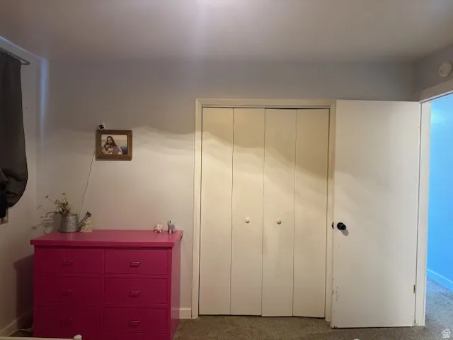 Bedroom with dark carpet and a closet