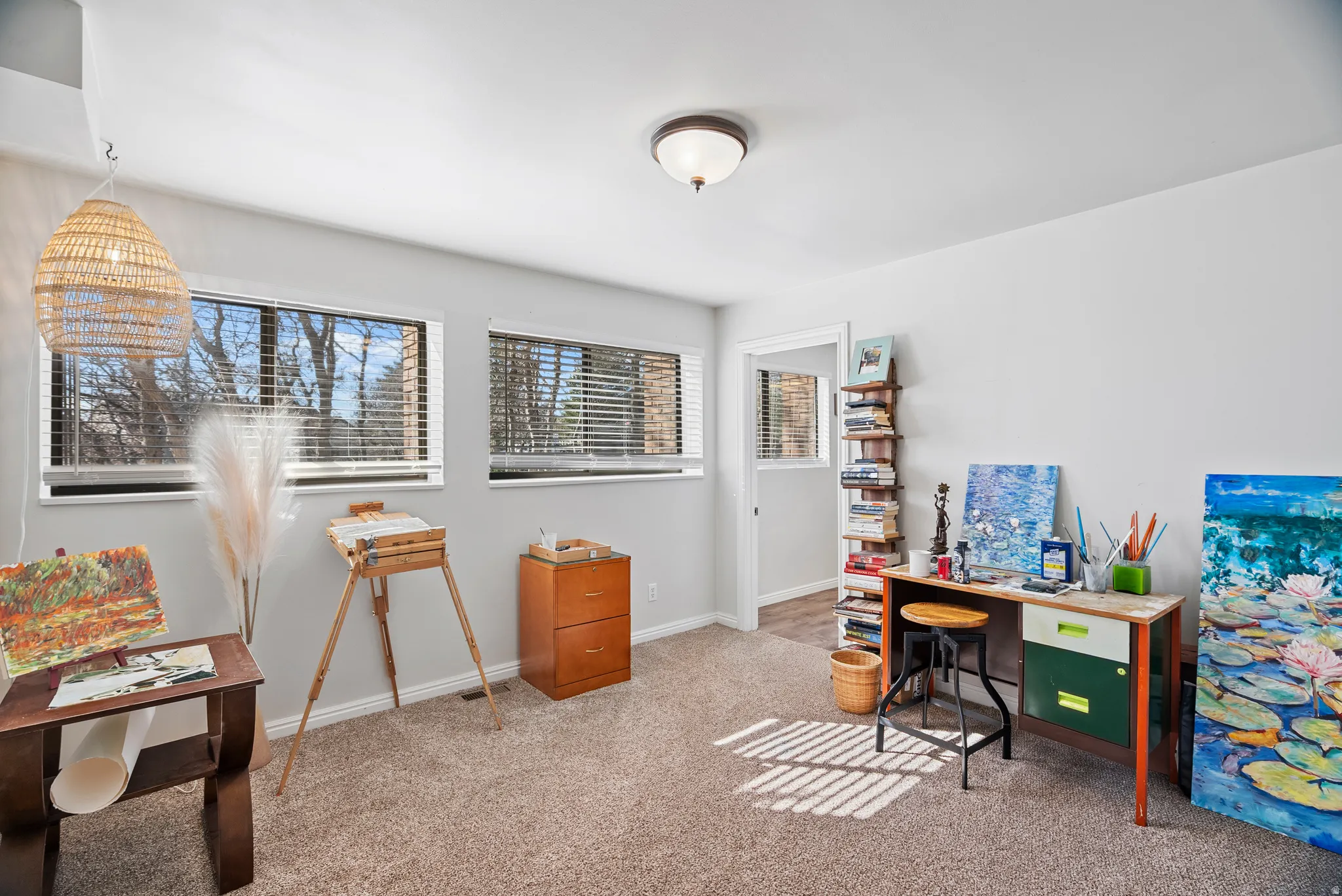 Downstairs: Office space with baseboards and light colored carpet
