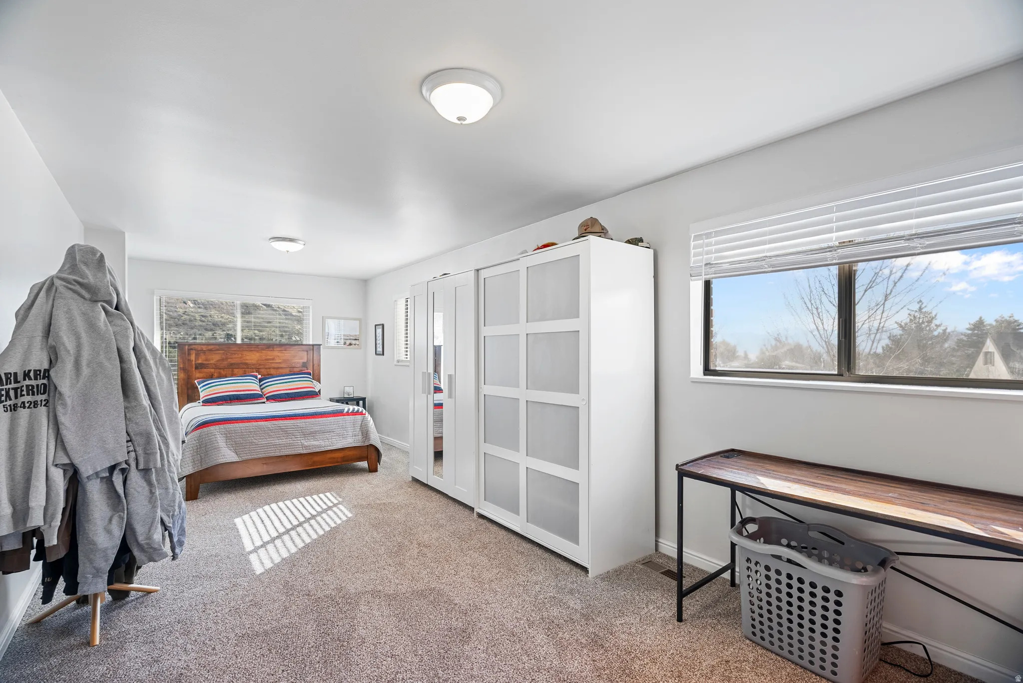 Downstairs: beddroom featuring light carpet and baseboards