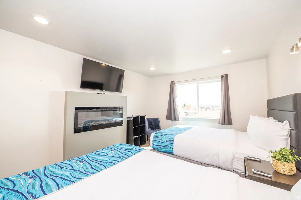 Bedroom featuring recessed lighting and a glass covered fireplace