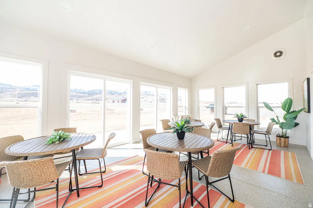 Dining space featuring vaulted ceiling, a mountain view, and dark speckled floor