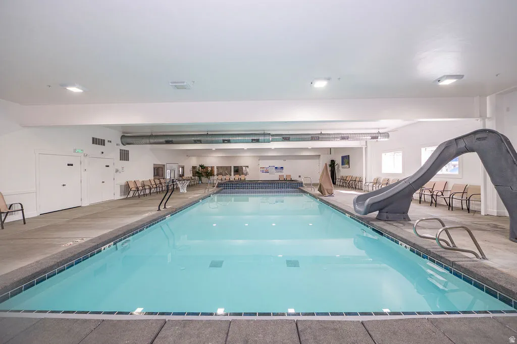 Indoor community pool featuring a water slide