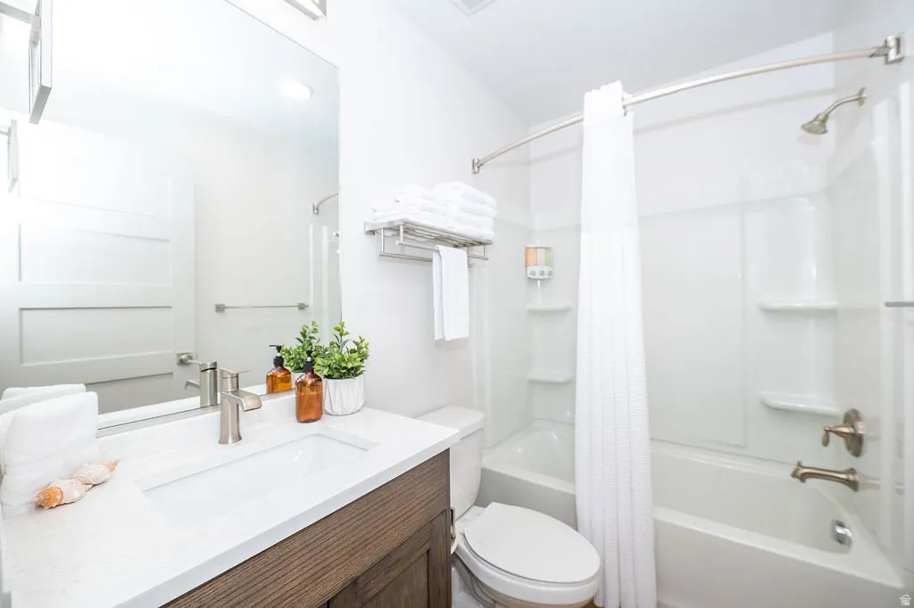 Bathroom featuring vanity and shower / bath combo with shower curtain
