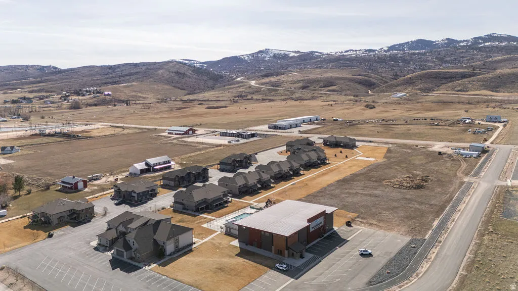 Aerial view of property and surrounding area featuring a mountainous background, nearby suburban area, and rural landscape