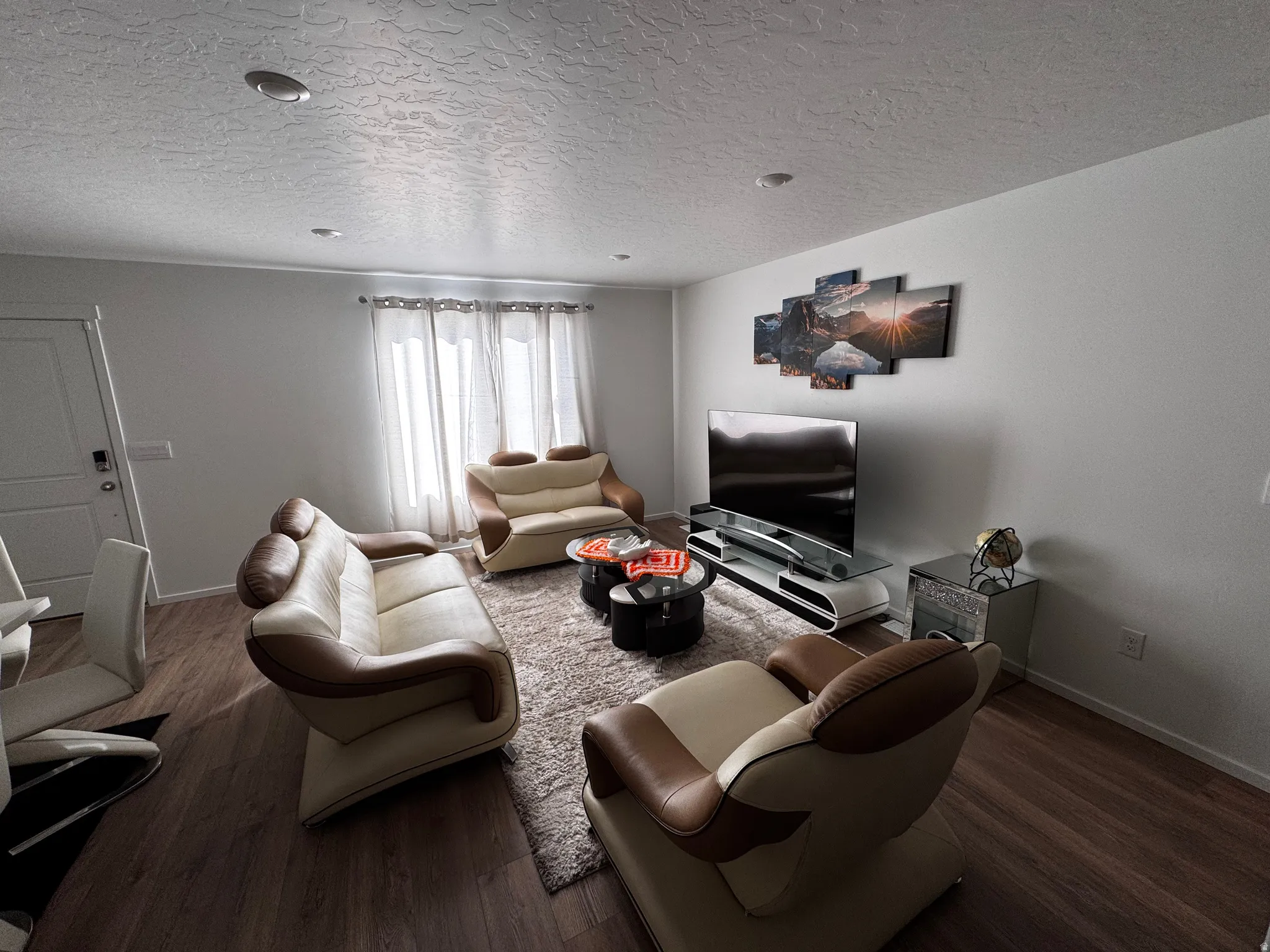 Living area featuring dark wood-style floors and a textured ceiling