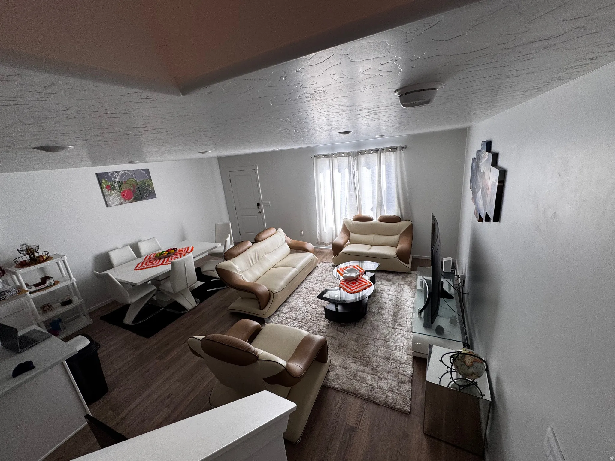 Living area featuring wood finished floors and a textured ceiling