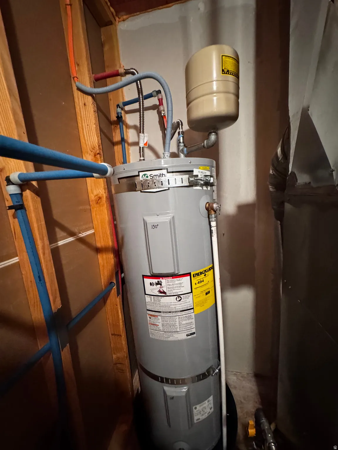 Utility room featuring strapped water heater