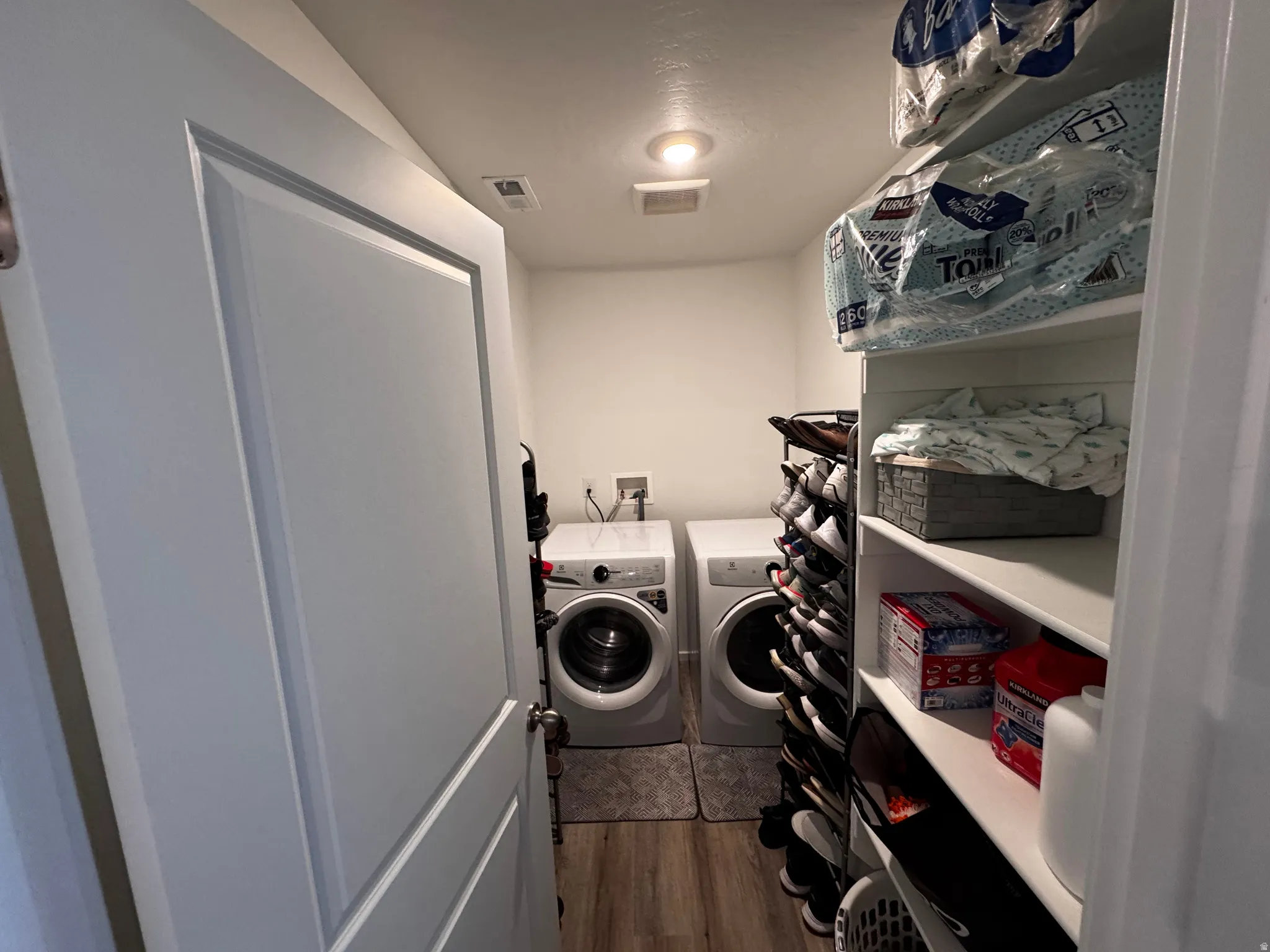 Laundry area with dark wood-type flooring and separate washer and dryer
