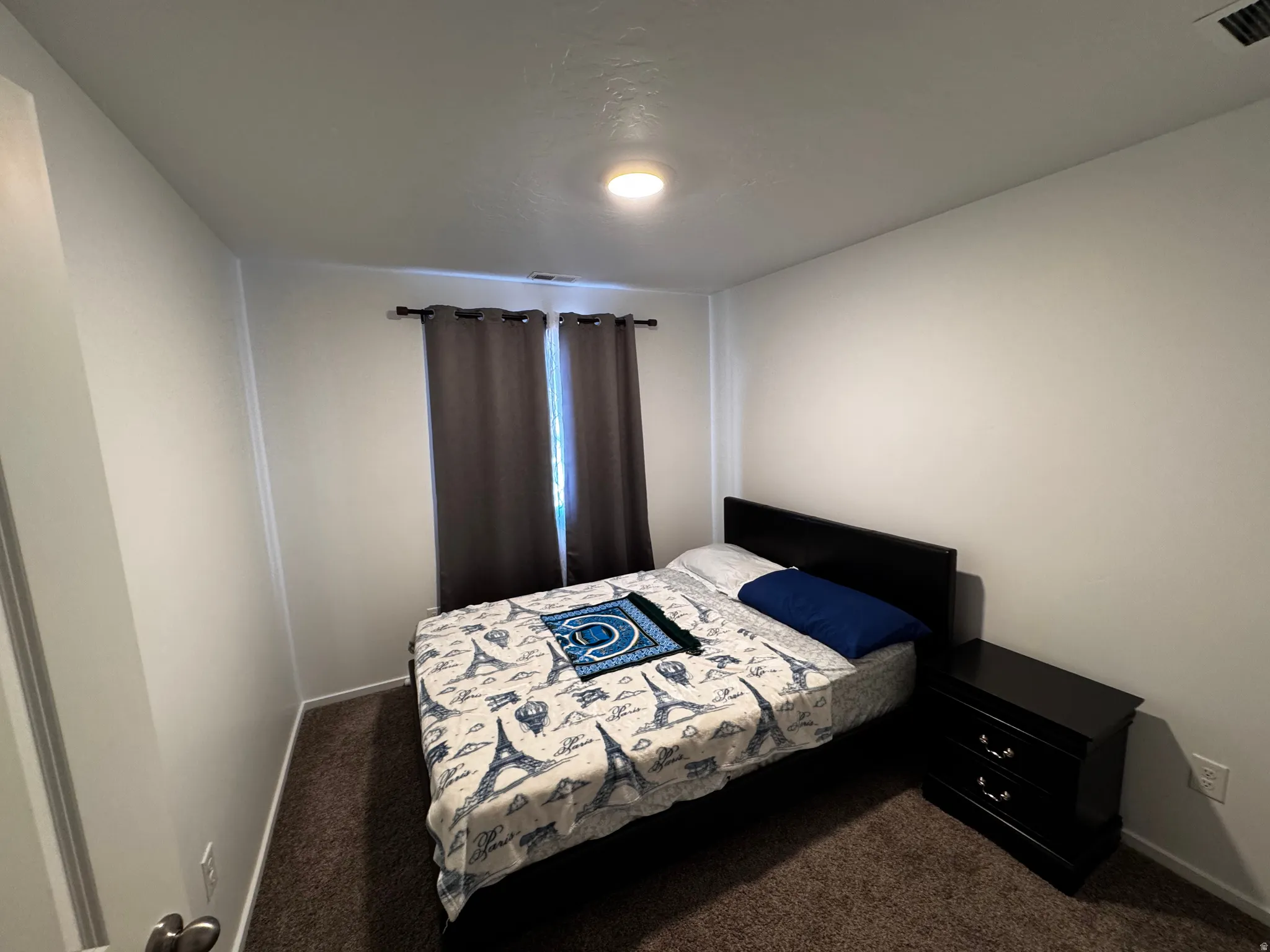 Bedroom featuring dark colored carpet
