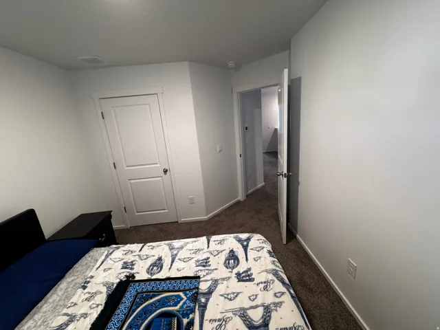 Bedroom featuring dark carpet and a closet