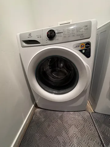 Laundry area with washer / dryer and tile patterned flooring