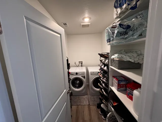 Laundry area with dark wood-type flooring and separate washer and dryer