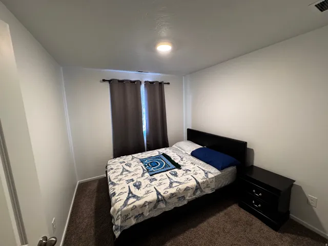 Bedroom featuring dark colored carpet