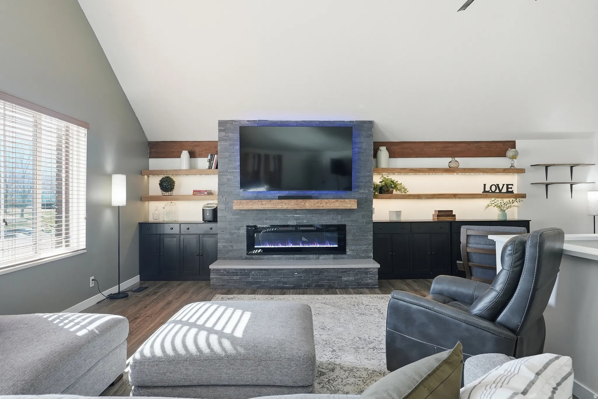 Living area with a glass covered fireplace, and lofted ceiling