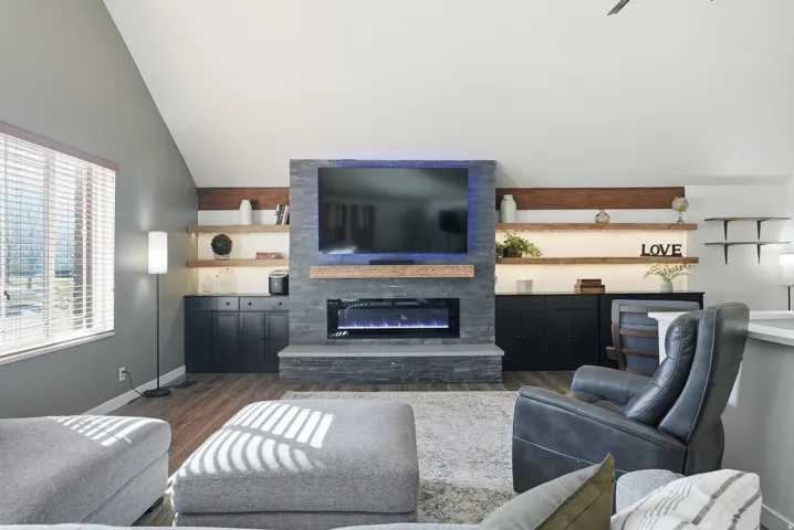 Living area with a glass covered fireplace, and lofted ceiling