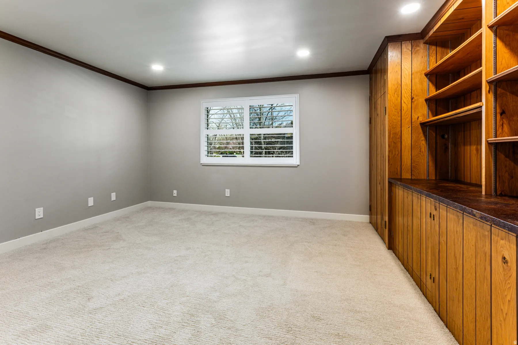 Empty room with ornamental molding, light colored carpet, and recessed lighting