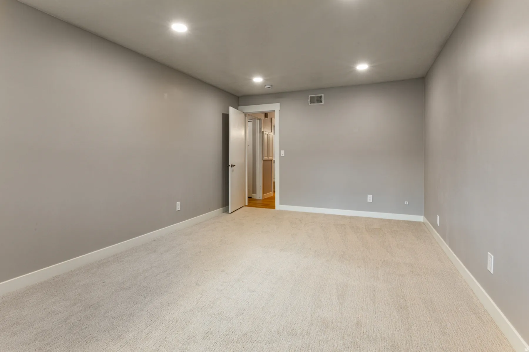 Spare room featuring recessed lighting and light carpet