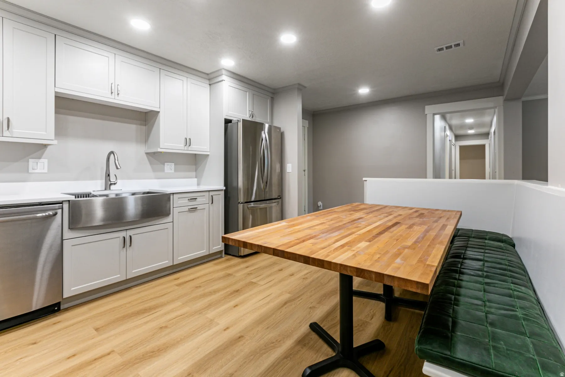 Kitchen with stainless steel appliances, light wood-style flooring, recessed lighting, white cabinets, and butcher block countertops