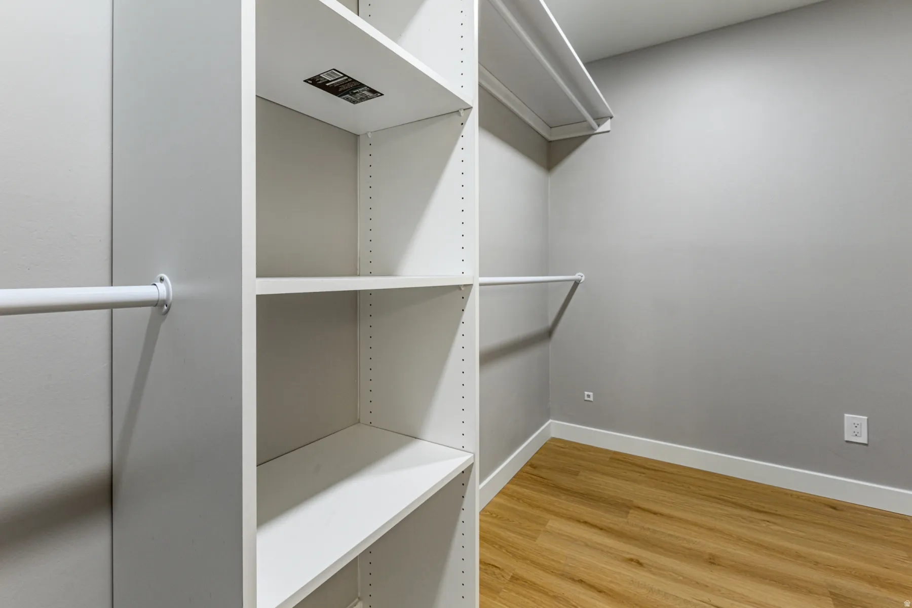 Walk in closet with light wood-style floors