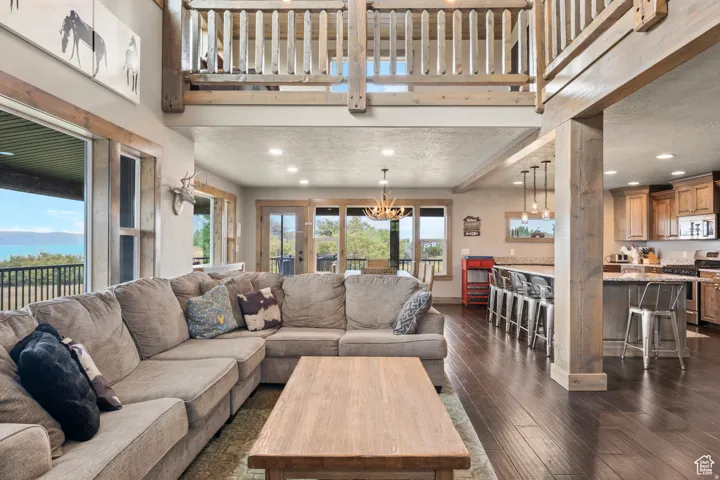 Living area with recessed lighting, dark wood-style floors, and a high ceiling