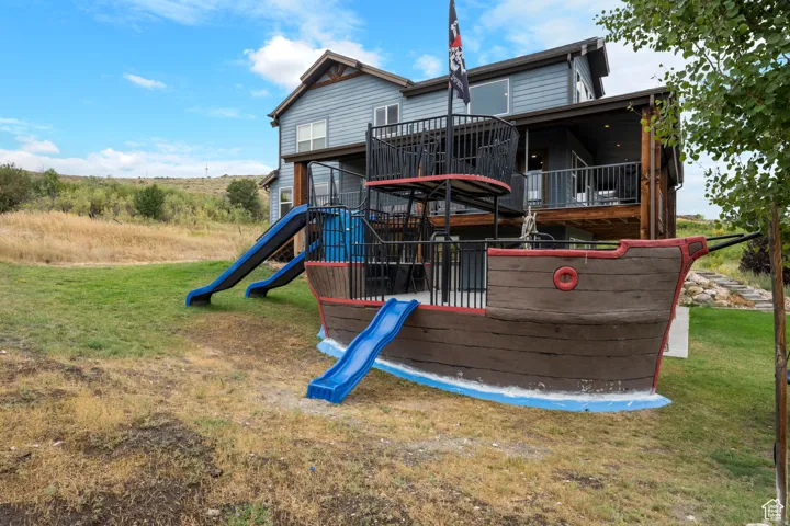 Back of property with a yard and a playground
