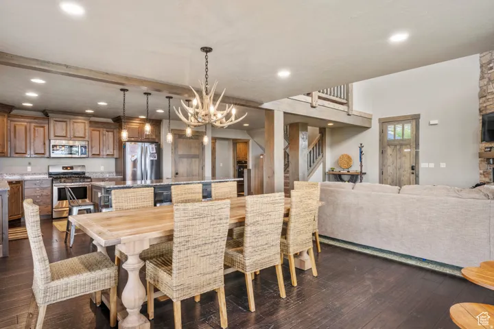 Dining room with dark wood finished floors and suspended lighting