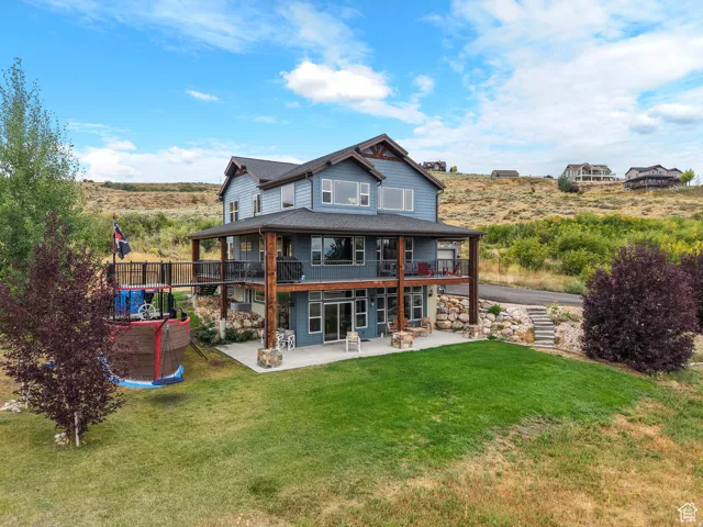 Back of house with a patio area, a yard, and a balcony