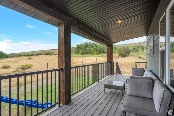 Wooden deck with a lawn and a rural view