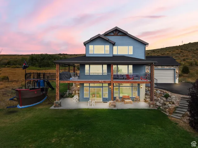 Back of property with a patio, a balcony, and a yard