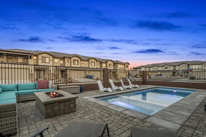 Integrated pool / spa featuring a residential view, a patio, and an outdoor living space with a fire pit
