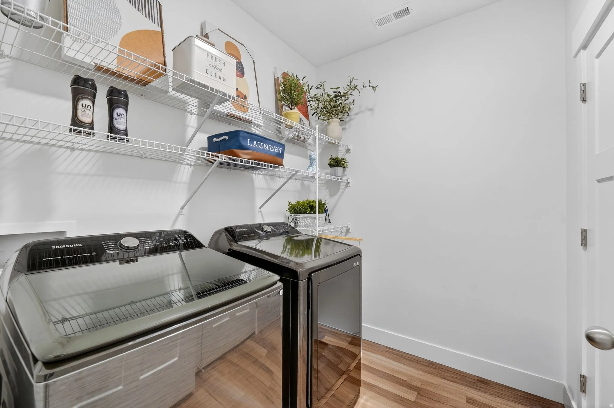 Laundry area featuring light wood-style flooring and separate washer and dryer