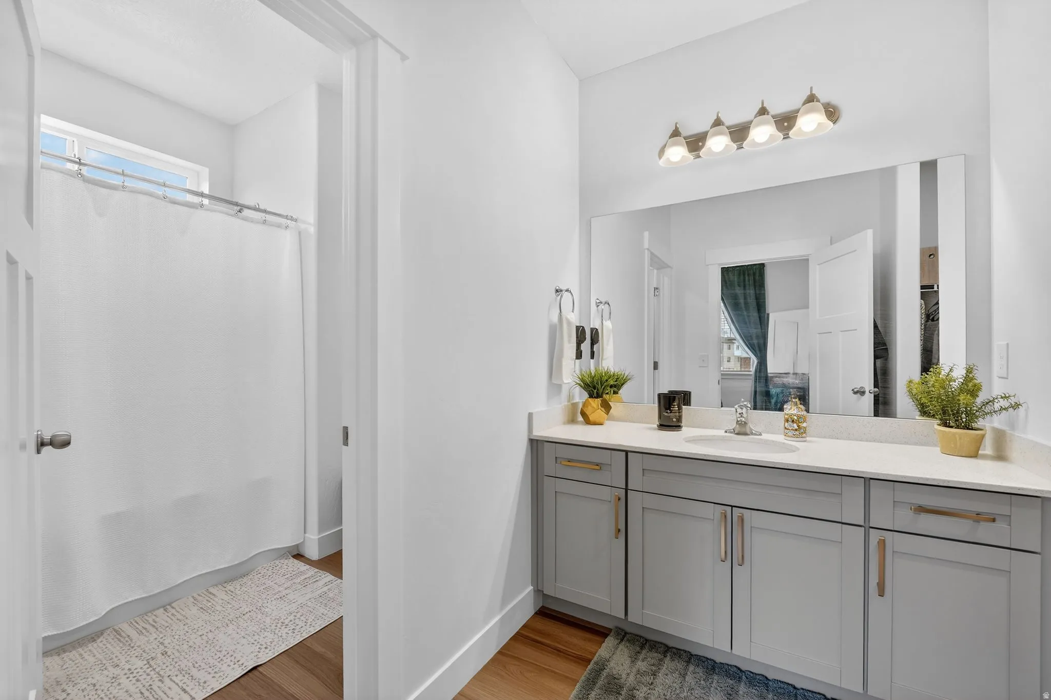 Bathroom featuring vanity, a shower with shower curtain, and light wood finished floors